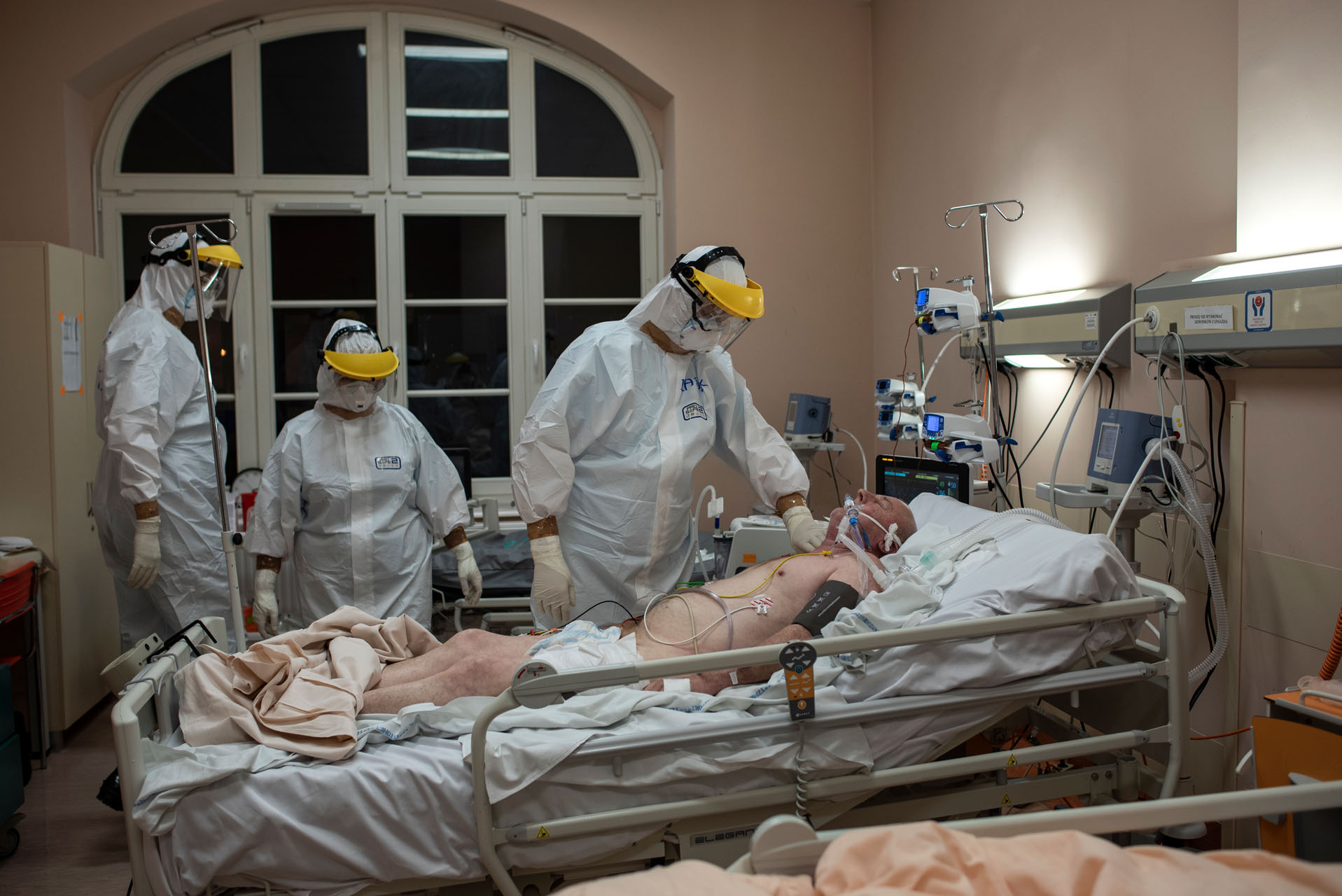 Pacjent przetransportowany z innego szpitala jest przygotowywany do podłączenia do respiratora. 

